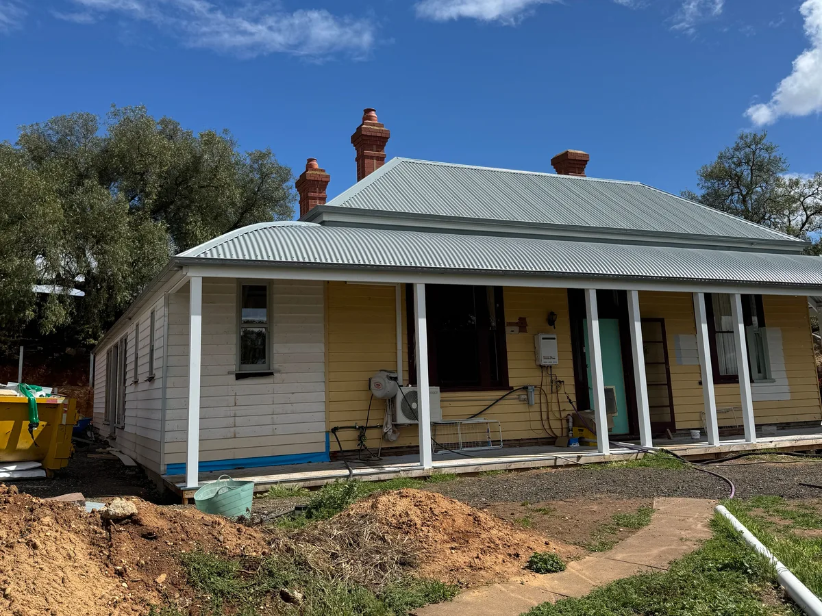 The same heritage home with its front verandah roofed in corrugated metal