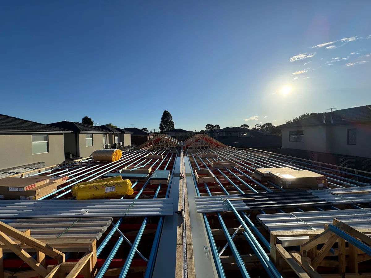 Steel roof framing across a townhouse development before roofing