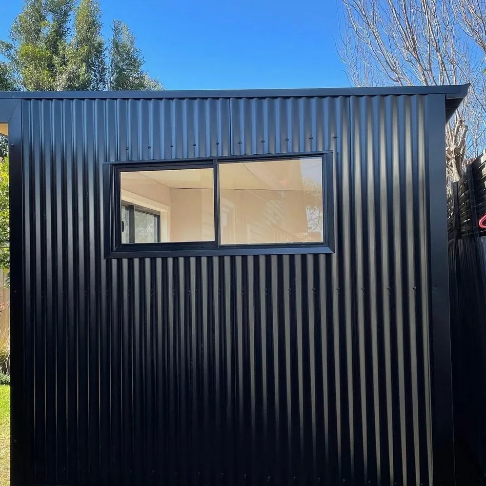Black vertical metal cladding on a small studio with a sliding window