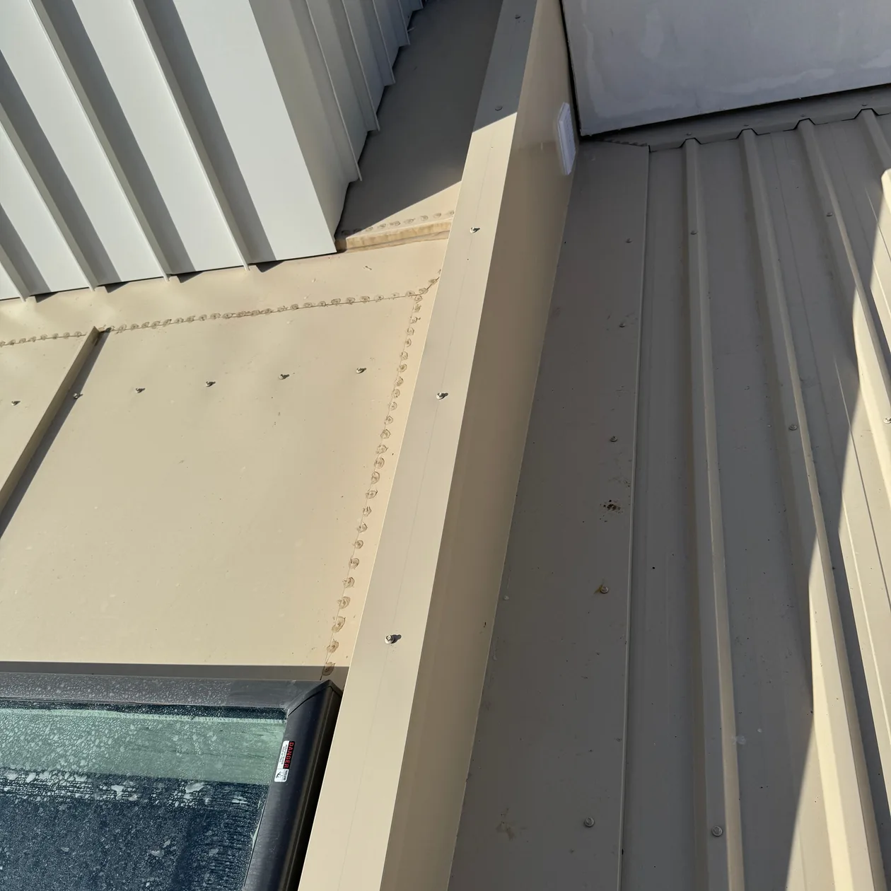Metal cladding meeting a roof with a folded flashing detail
