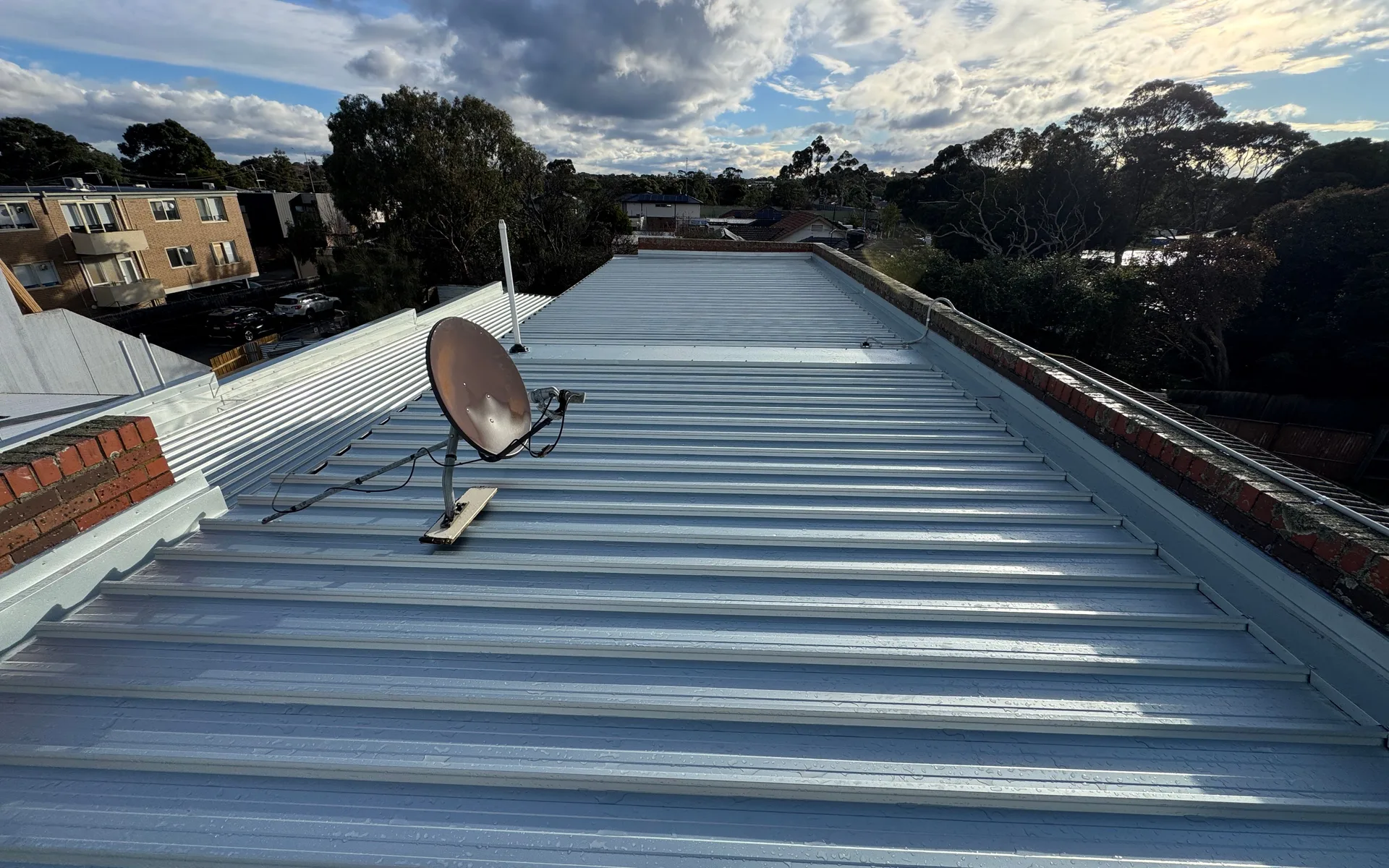 Long run of corrugated metal roof sheets with a satellite dish