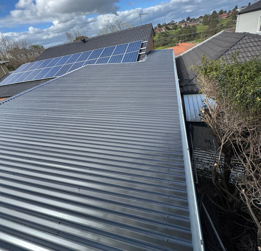 Grey corrugated metal roof running alongside rooftop solar panels
