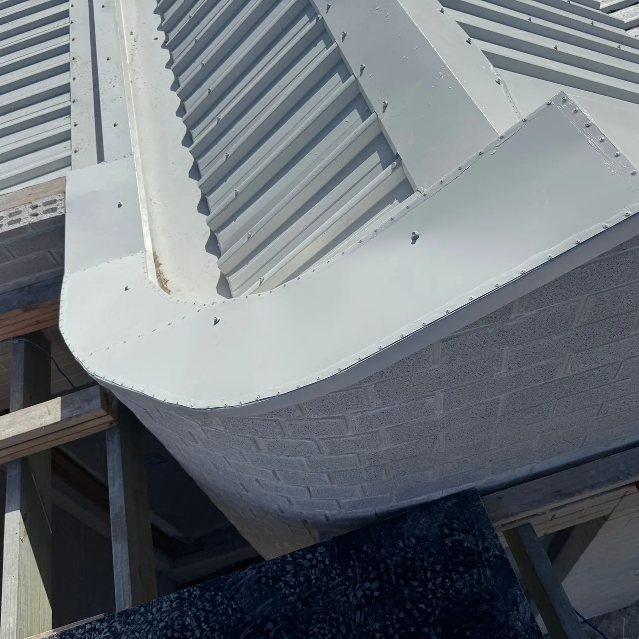 Curved edge of a pale metal roof