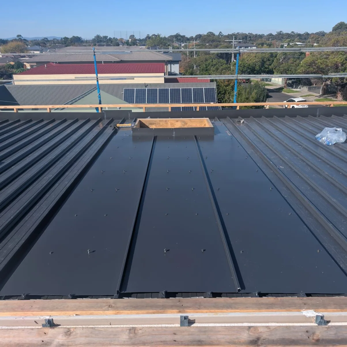 Dark metal roof sheets running across a low-pitch roof