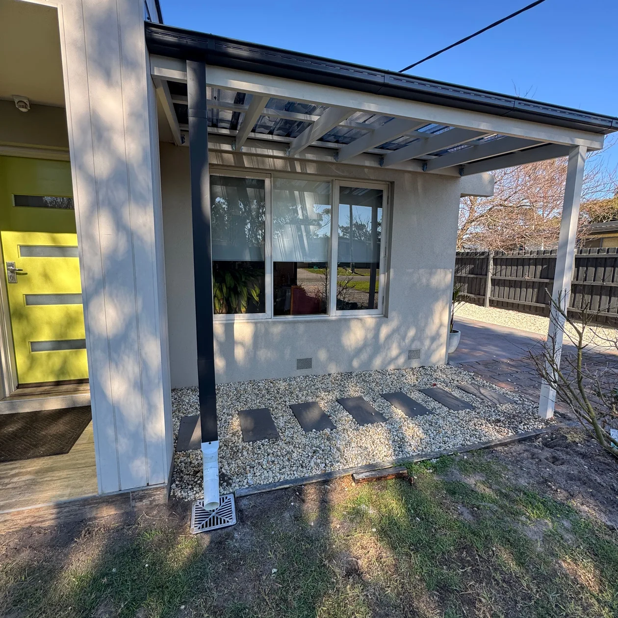Dark downpipe running down a verandah post