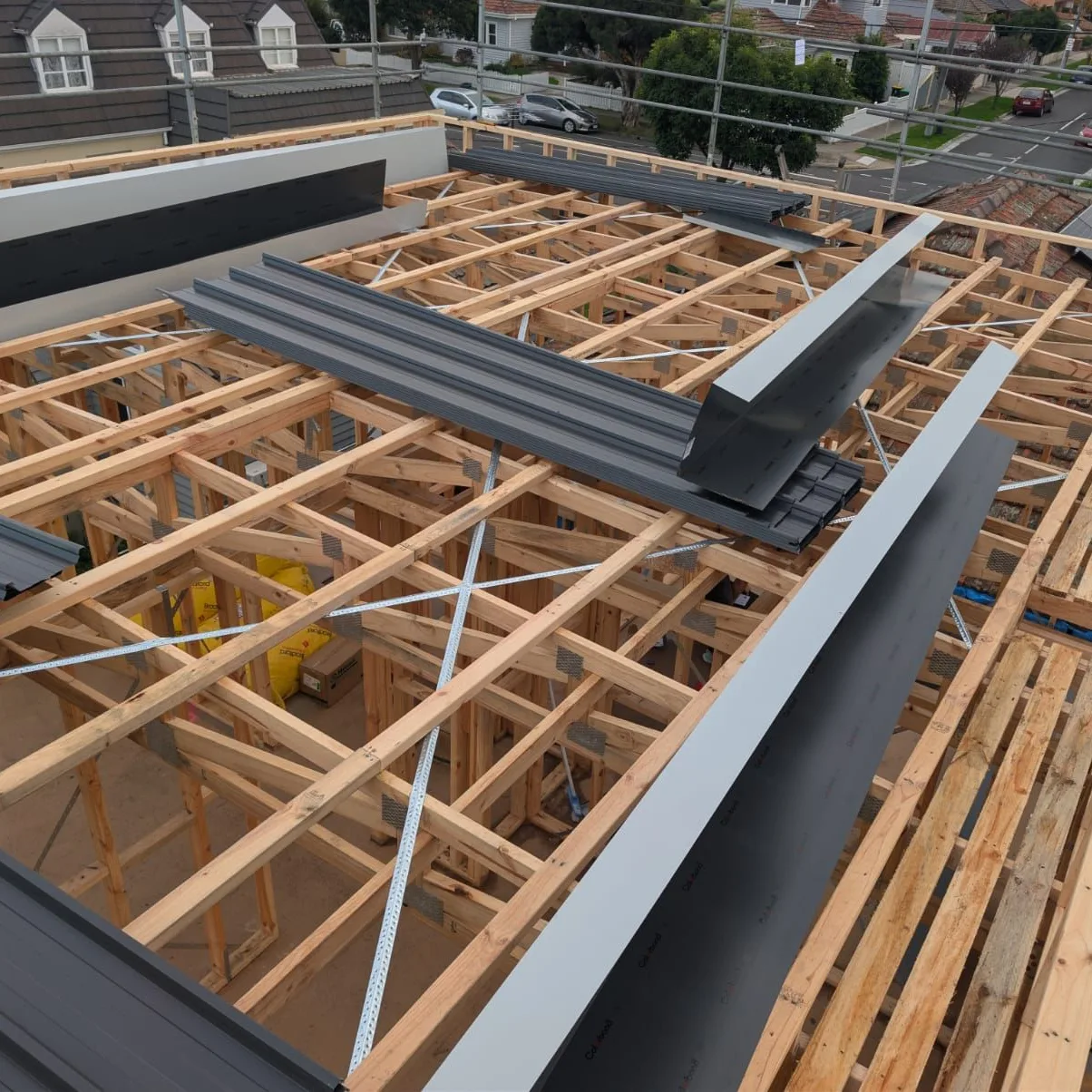 Roof framing exposed while new metal roofing and flashings are being installed